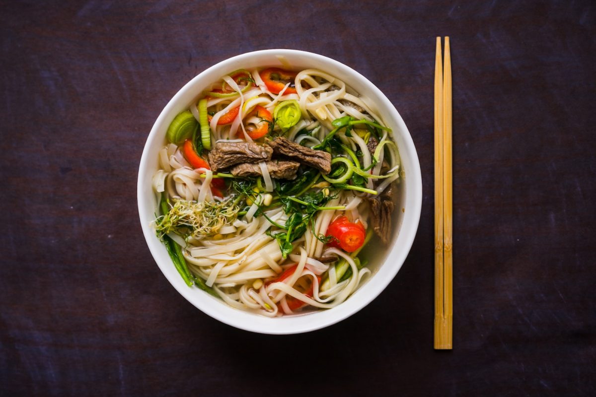 a bowl of noodle soup with chopsticks on the side