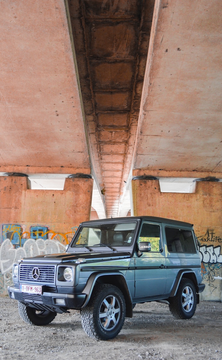 blue and black Mercedes-Benz SUV under bridge during daytime