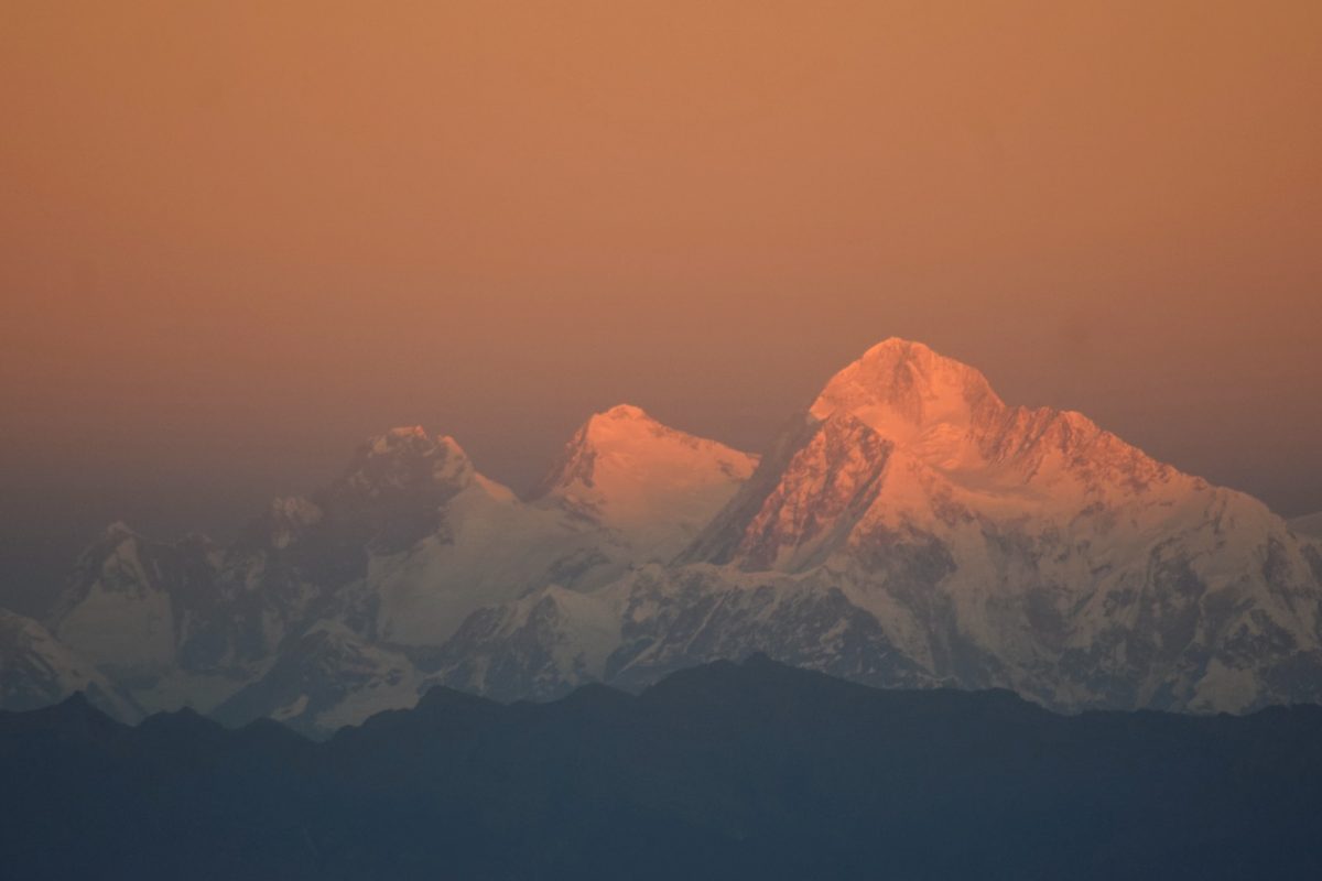 a view of a snow covered mountain at sunset