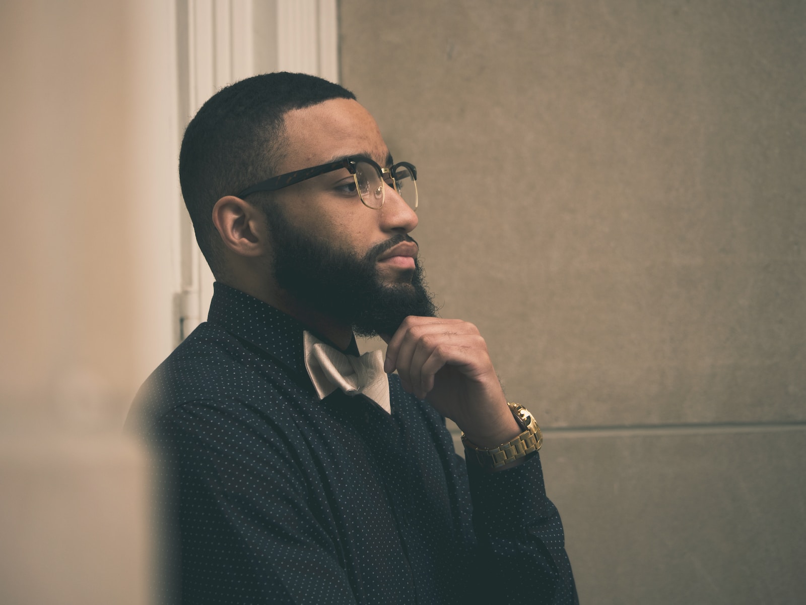 a man with a beard and glasses looking off into the distance