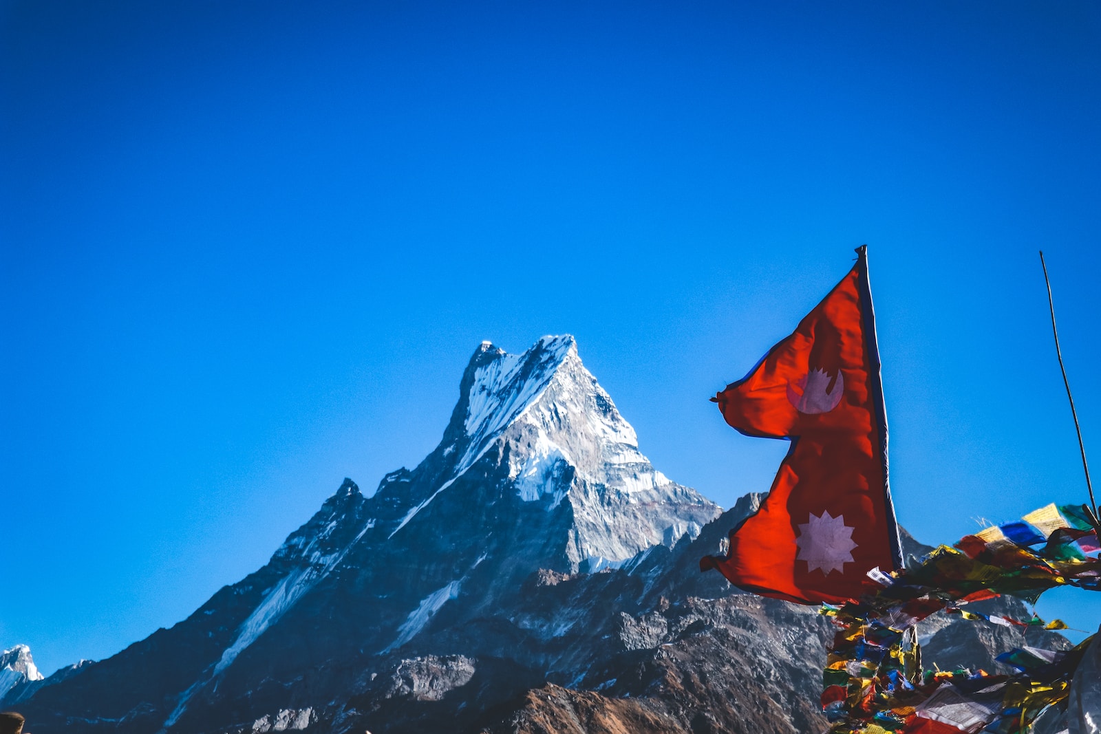 red flah near snow covered mountain during daytime
