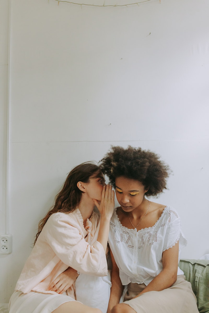 Person Whispering Near the Woman's Ear