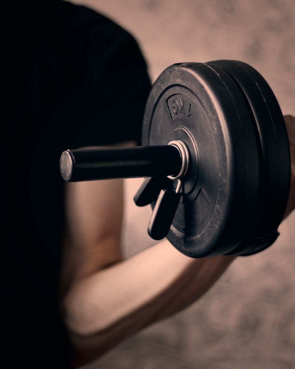 black and gray dumbbell on persons hand