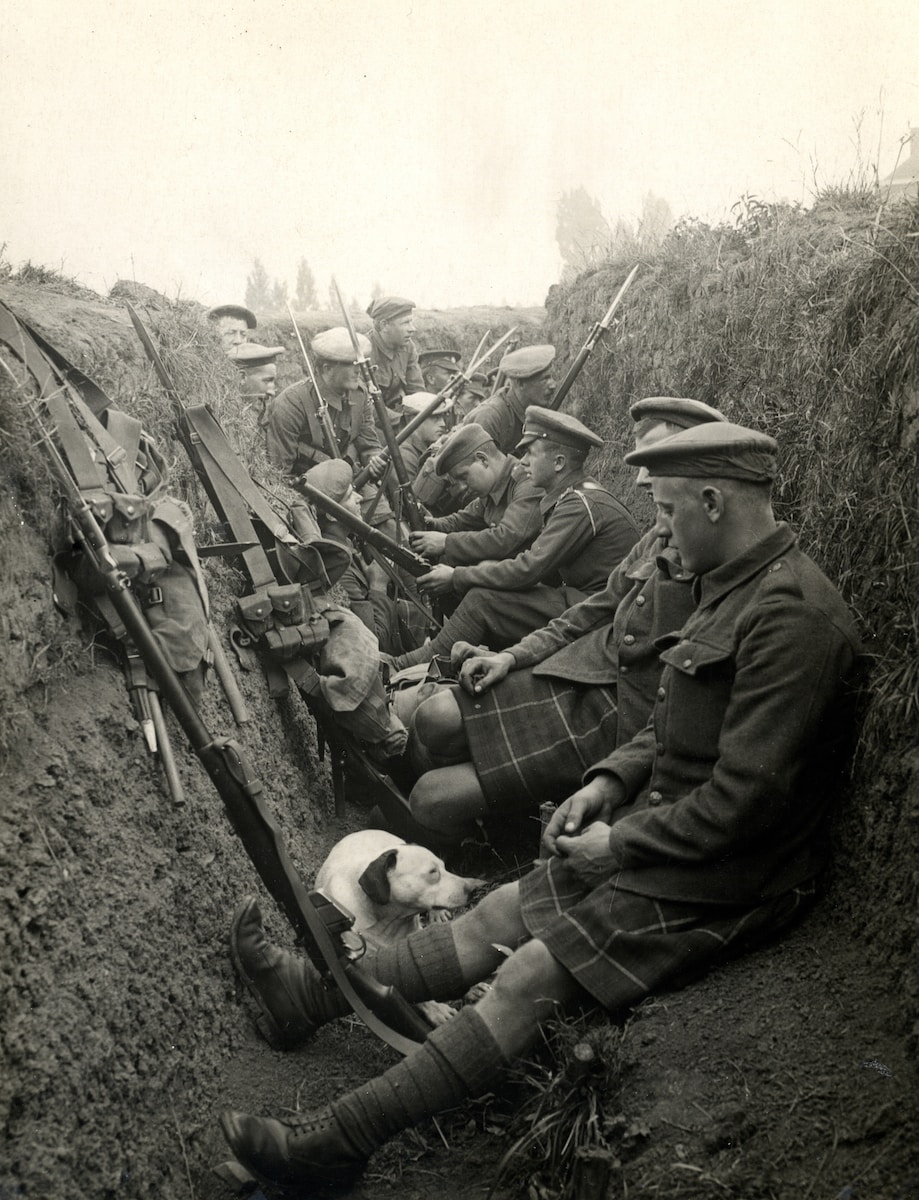 a group of men sitting next to each other in a trench