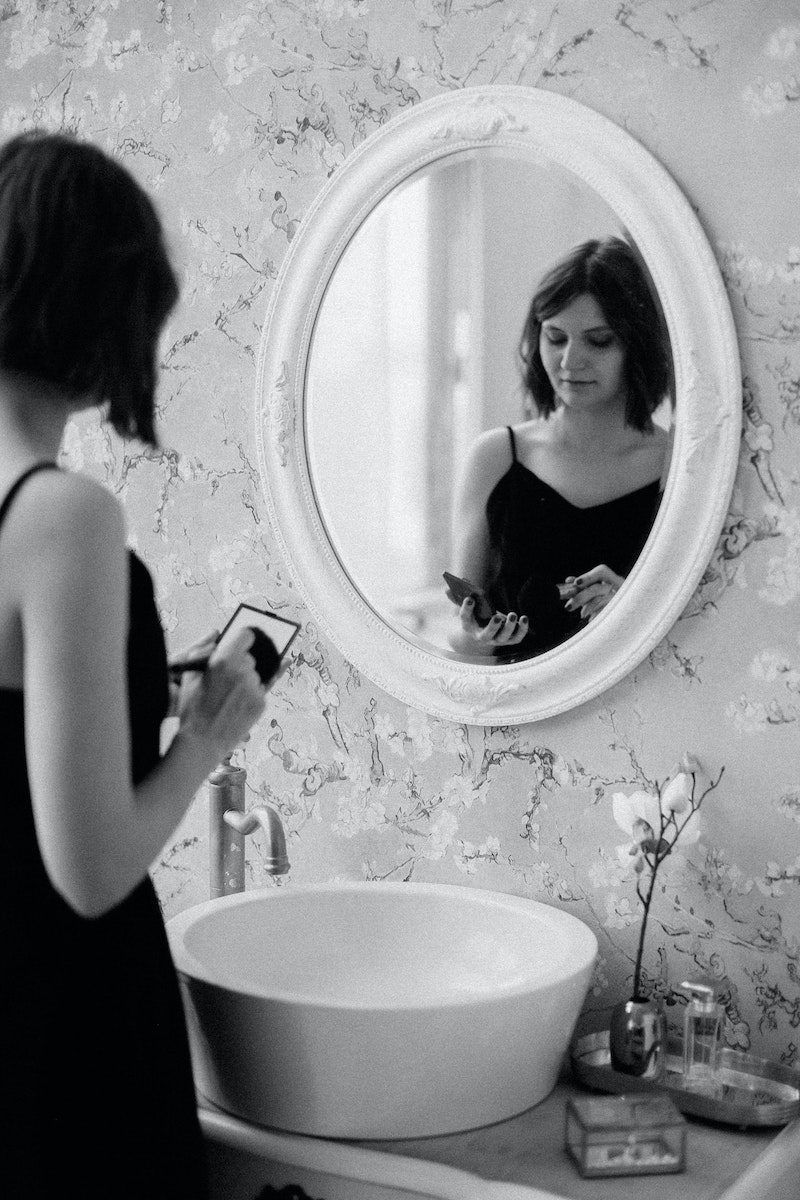 Grayscale Photo of Woman in Front of Mirror