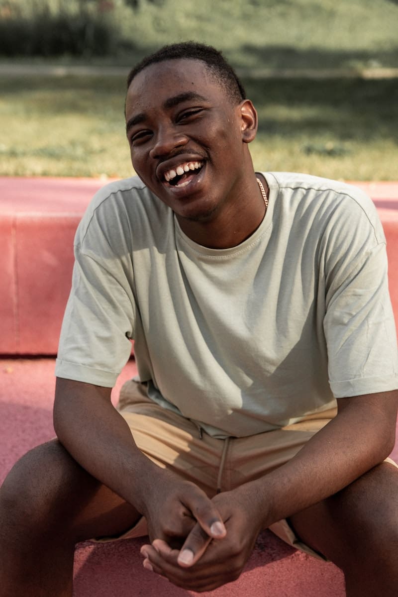 Laughing black man sitting on bench in park