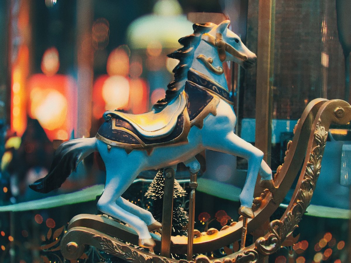 selective focus photo of blue horse carousel