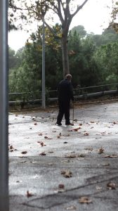 man in black jacket walking on gray pathway during daytime