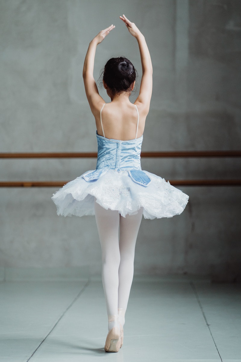 Ballet dancer on tiptoes with hands up