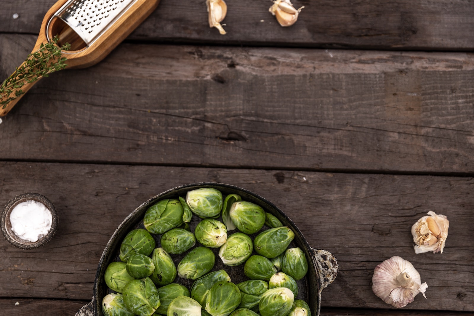 Cast Iron Pan with Brussels Sprout on Wooden Surface