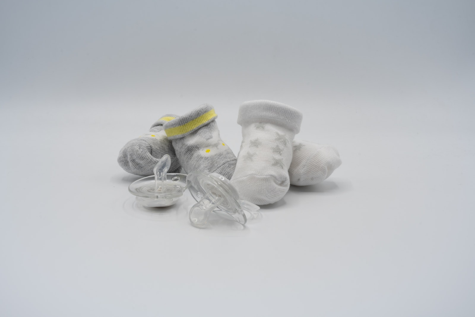 Socks and Pacifiers on White Surface