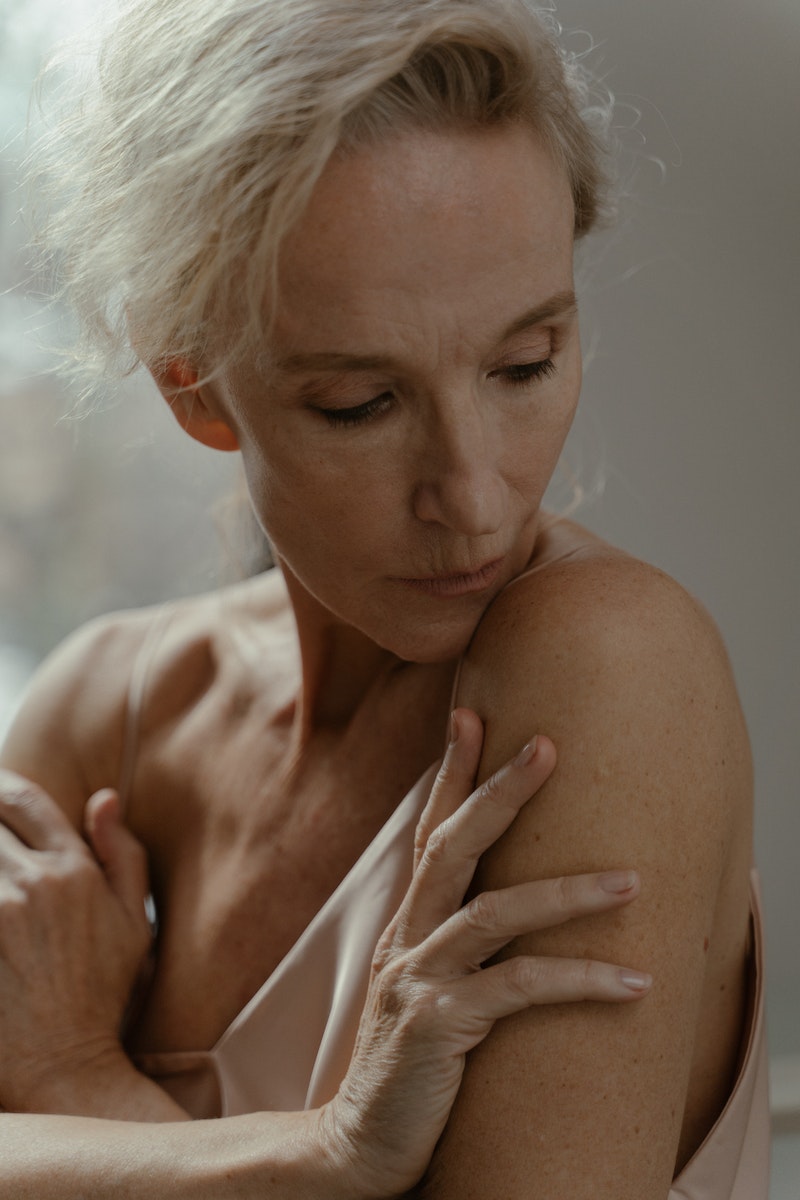 A Portrait of an Elderly Woman Touching her Skin