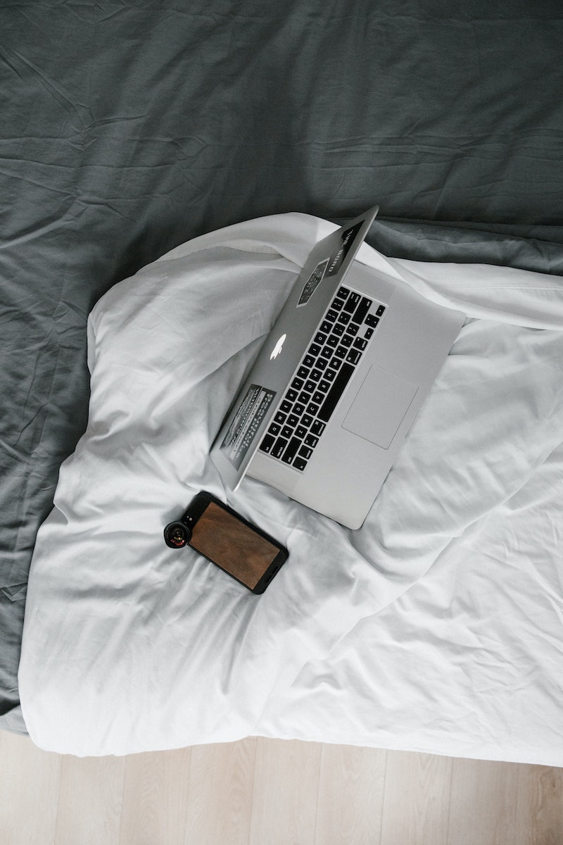 Silver Macbook Pro on White Bed Blanket