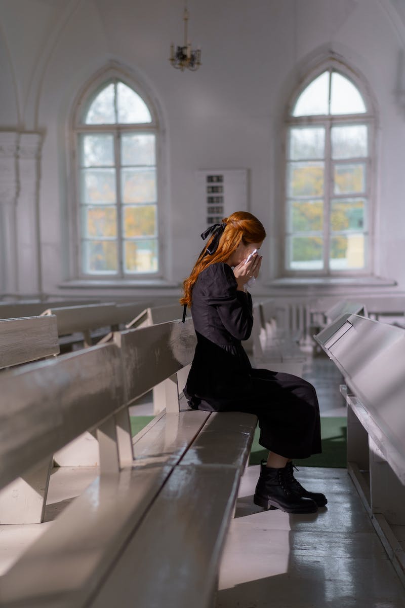 A Woman Crying while Sitting Inside the Church