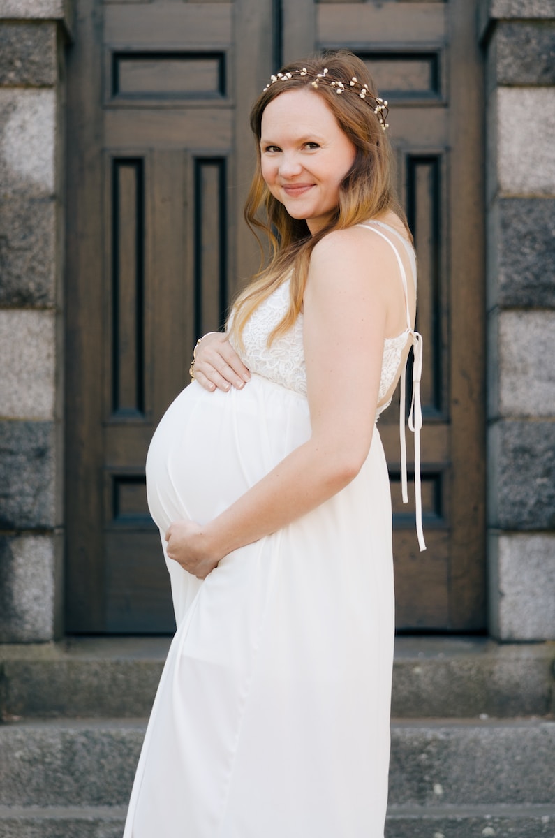 pregnant woman standing near wooden door