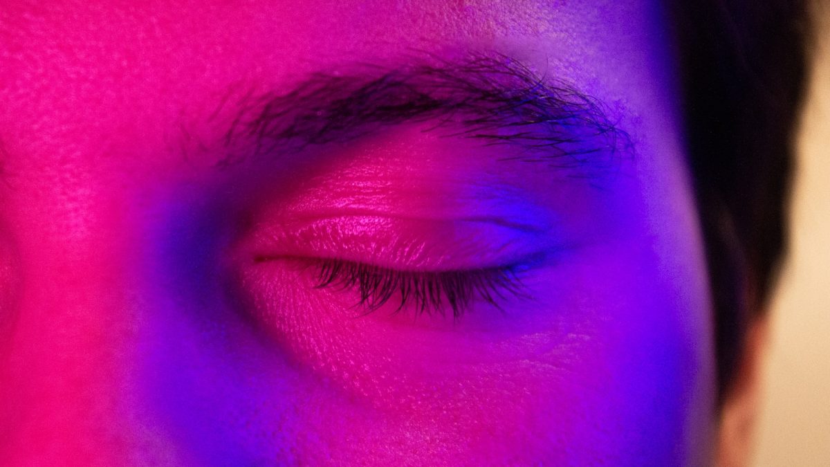 a close up of a person's eye with a purple light