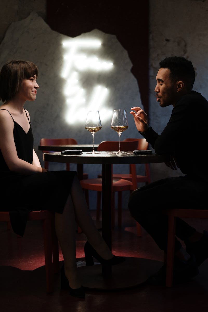 Man and Woman Sitting on Chair in Front of Table