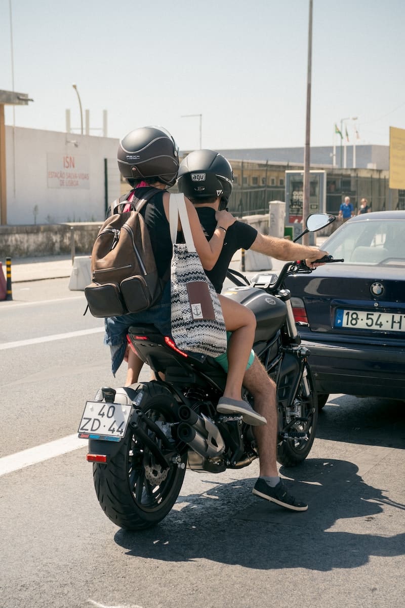 two people riding a motorcycle in the road