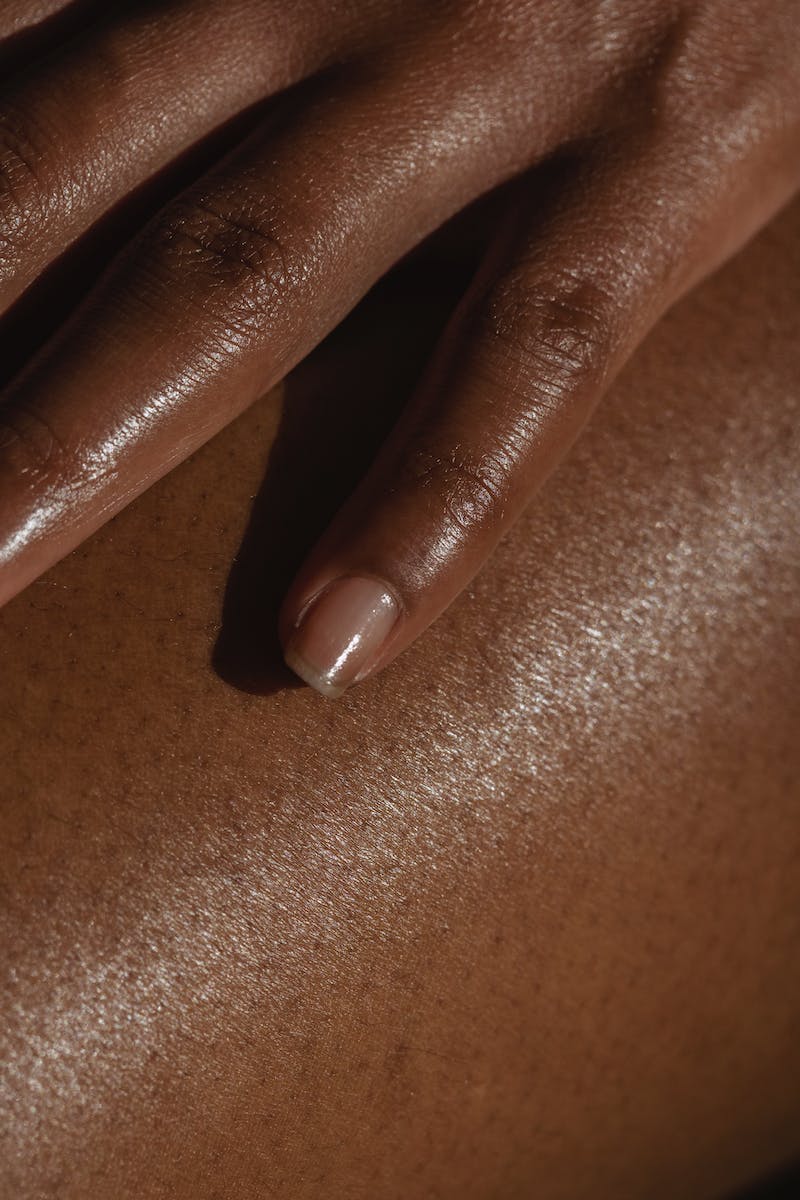 Crop ethnic person touching bare skin