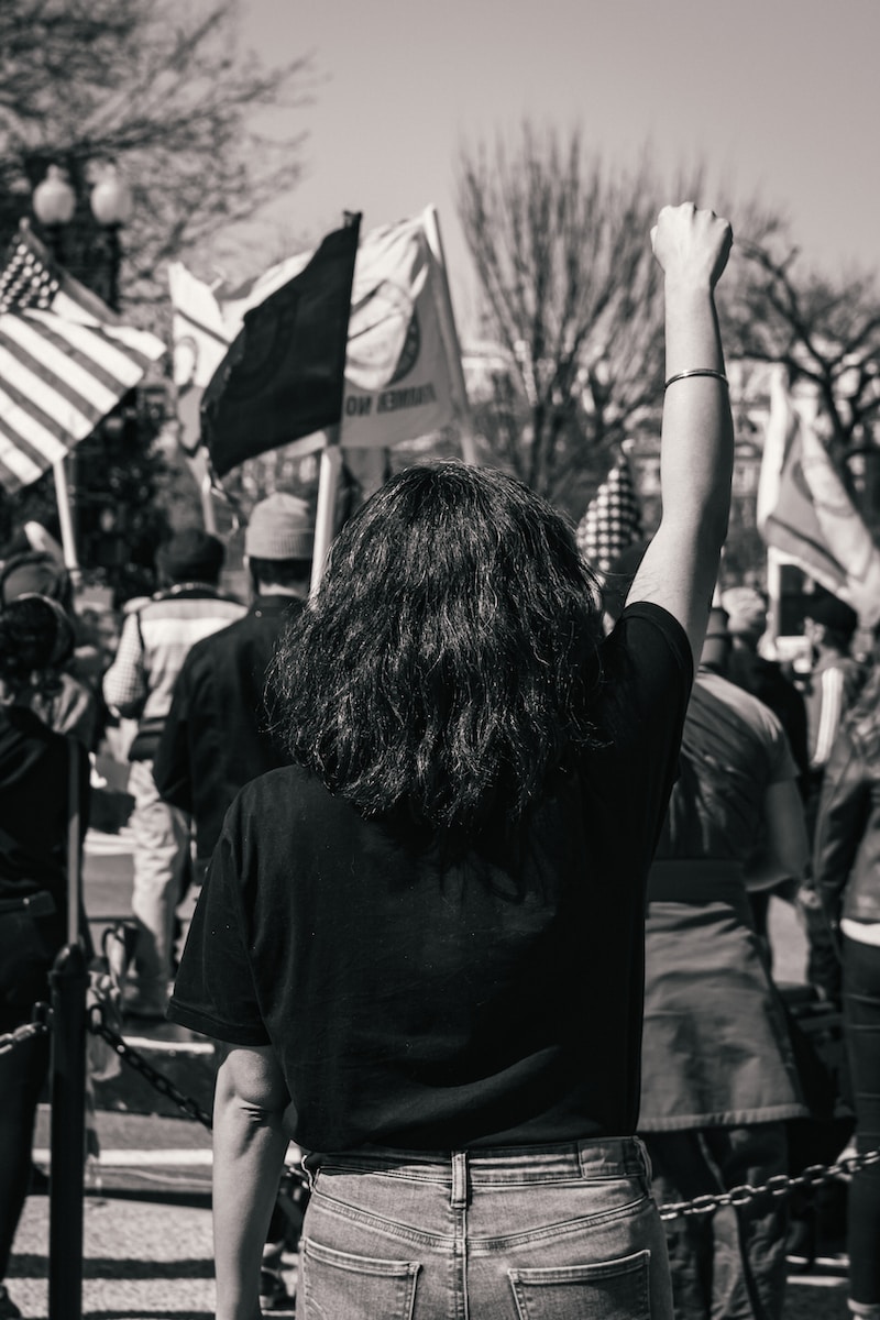 grayscale photo of woman in black shirt holding flag