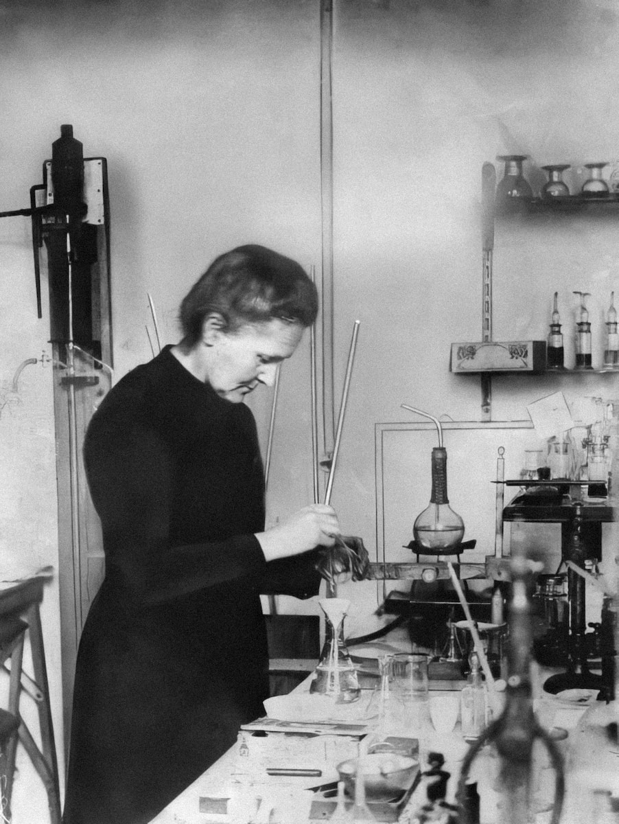 a woman working in a lab with a lot of bottles