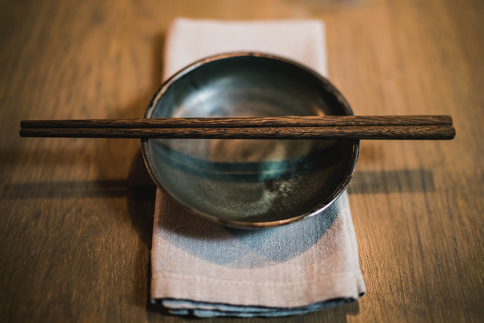 pair of brown chopsticks on round ceramic bowl