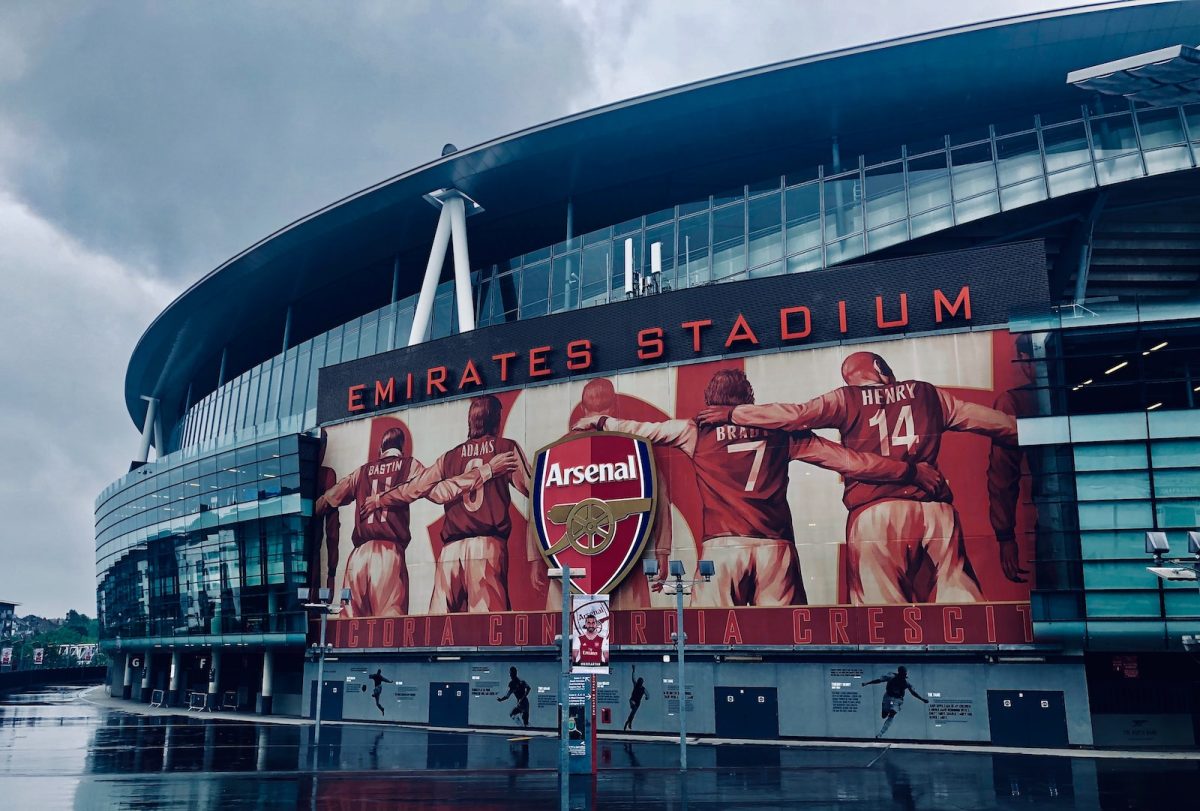 a man standing in front of the emirates stadium