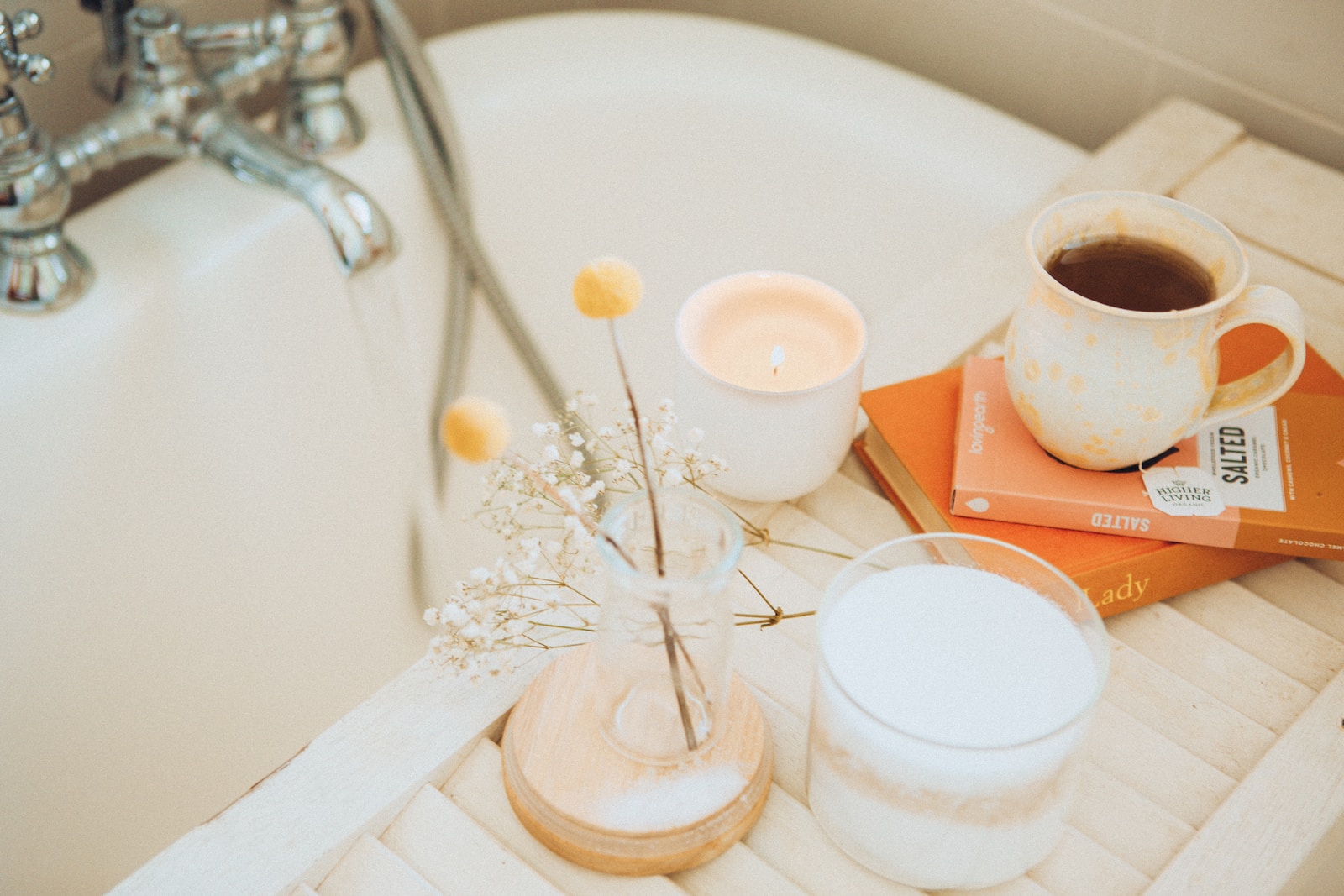 a cup of coffee and some books on a bathtub