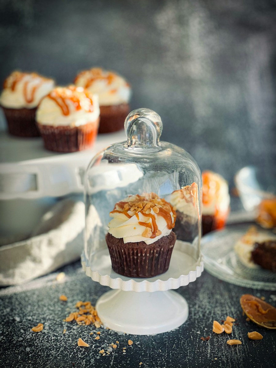 a cupcake under a glass dome on a table