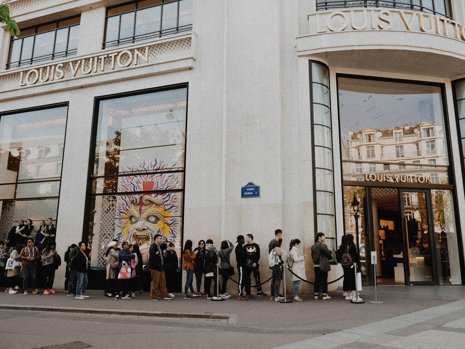people queuing beside Louis Vuitton store