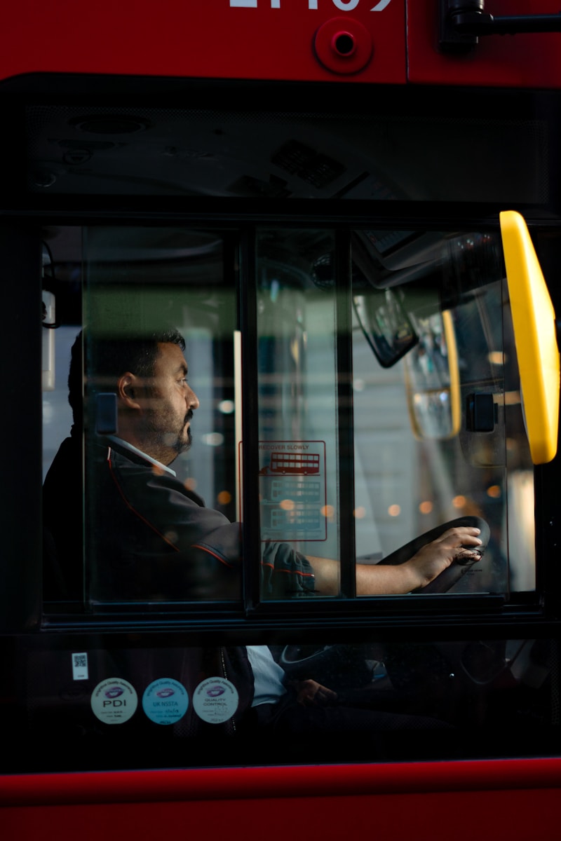 a man sitting in a bus driving down the street
