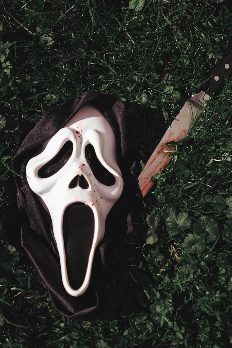a white mask with a knife sticking out of it