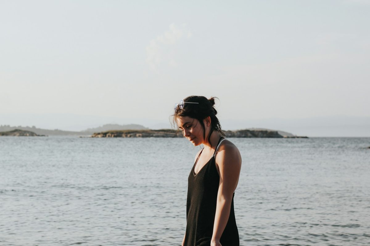 woman wearing black spaghetti strap dress beside beach