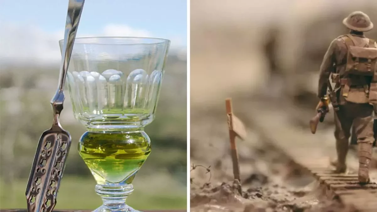 Pohár s absinthom a lyžička na ľavej strane, vojenská miniatúra na pravej strane v rozostrenom prostredí.