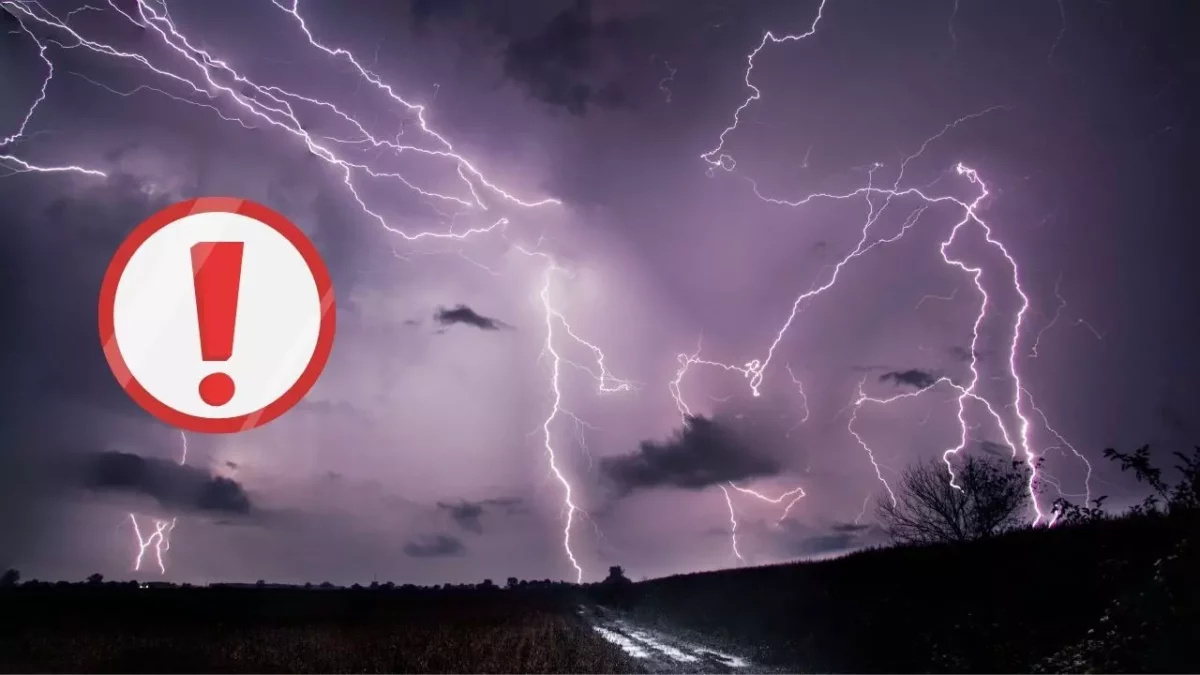 Blesky na nočnej oblohe s ikonou výstrahy, tmavá silueta krajiny v pozadí.
