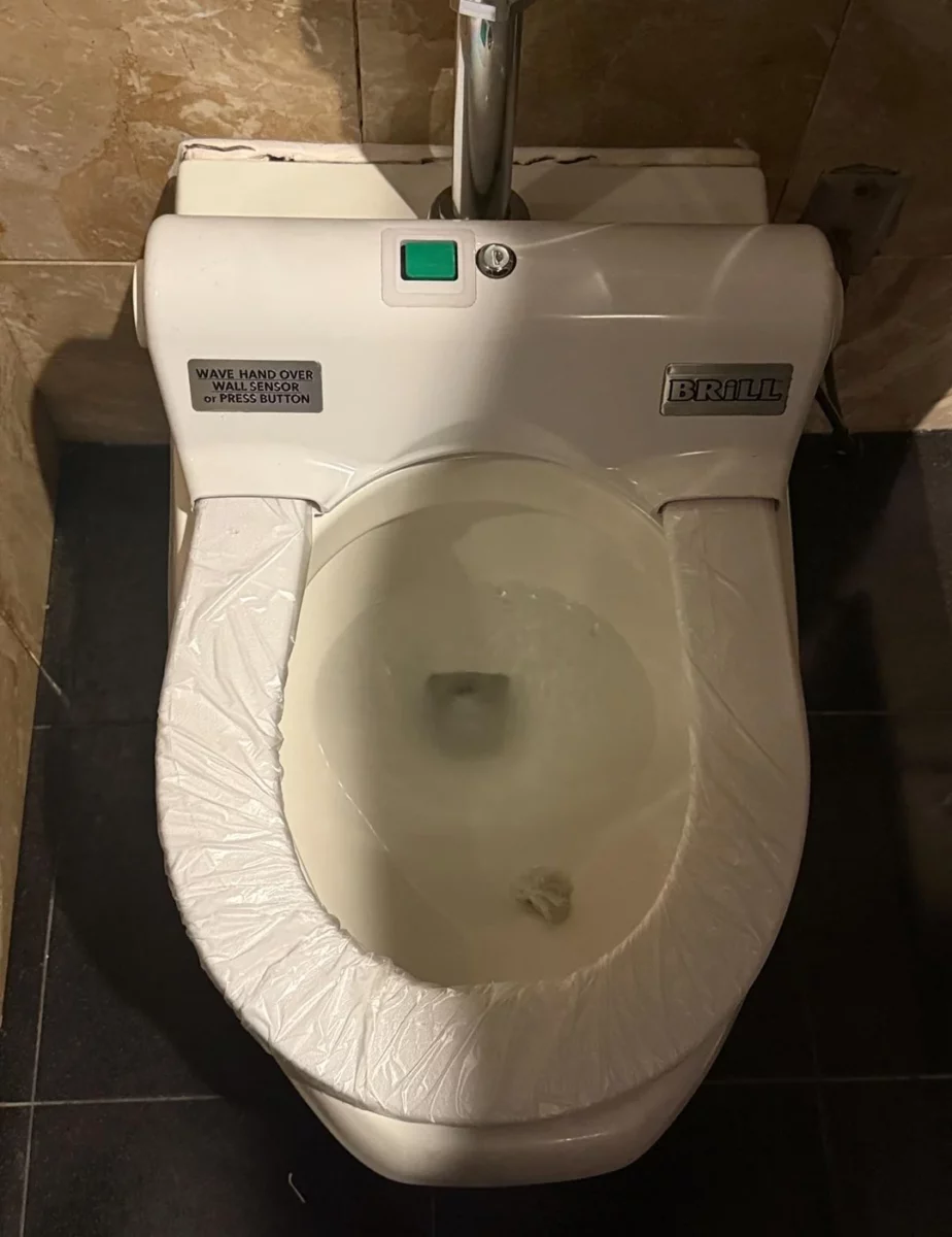 Moderná toaleta s automatickým senzorom a vymeniteľným sedátkom v kúpeľni.