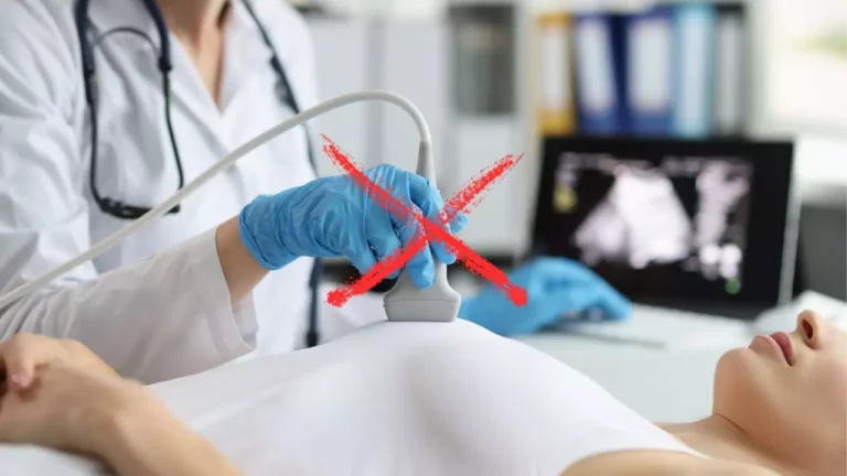 Lekár vykonáva ultrazvukové vyšetrenie tehotnej ženy, na obrázku je prekrížené.