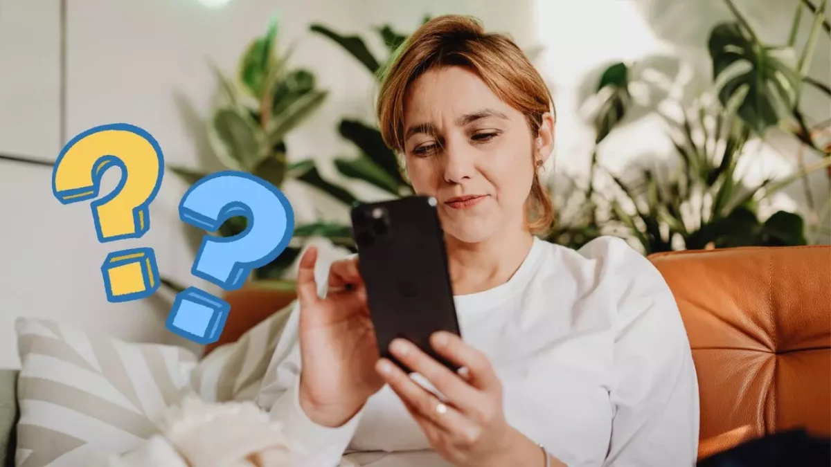 Žena v bielom tričku pozerá do smartfónu, na obrázku sú aj modro-žlté otázniky na pozadí so zeleňou.