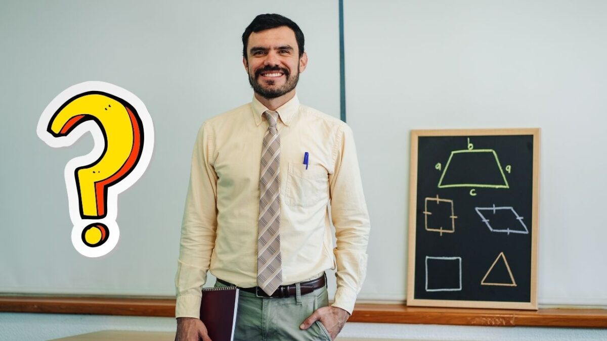 Učiteľ matematiky s tabuľou geometrických tvarov stojí vedľa veľkého otázniku v triede.
