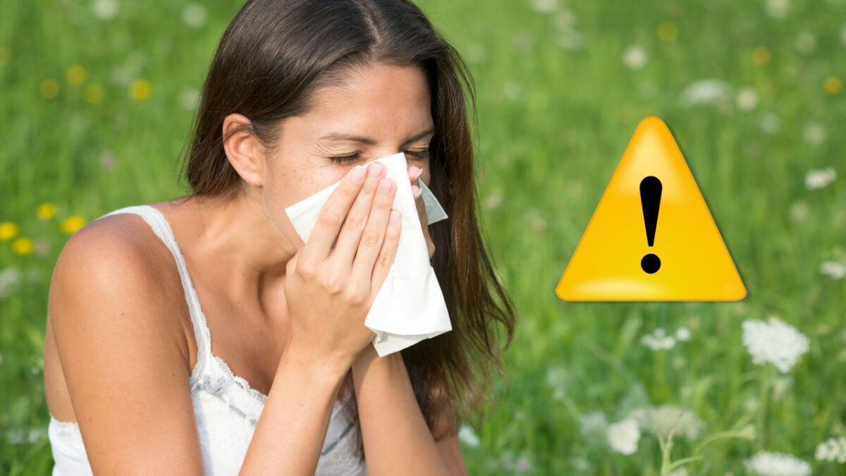 Žena kýchajúca v tráve, varovný symbol. Možná peľová alergia vonku.