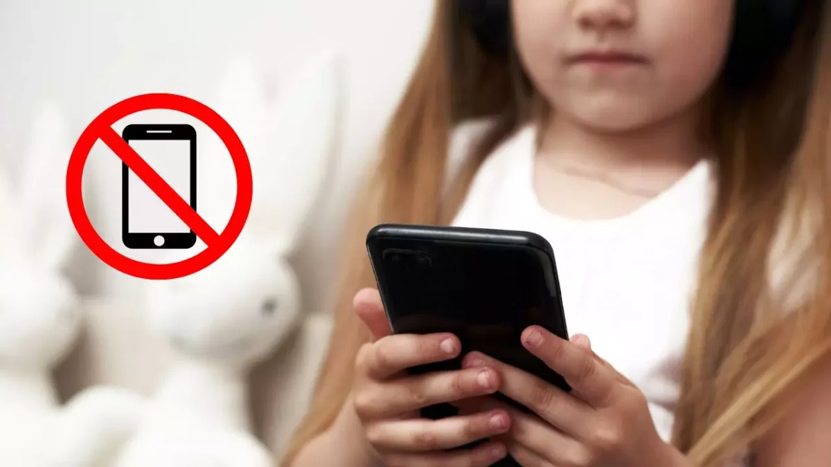 Dieťa so smartfónom a symbol zákazanej mobilnej zóny v pozadí.