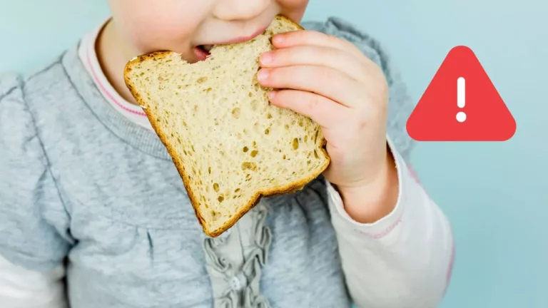 Dieťa s chlebom pri označení varovania, modré pozadie. Pozor na potravinové alergie.
