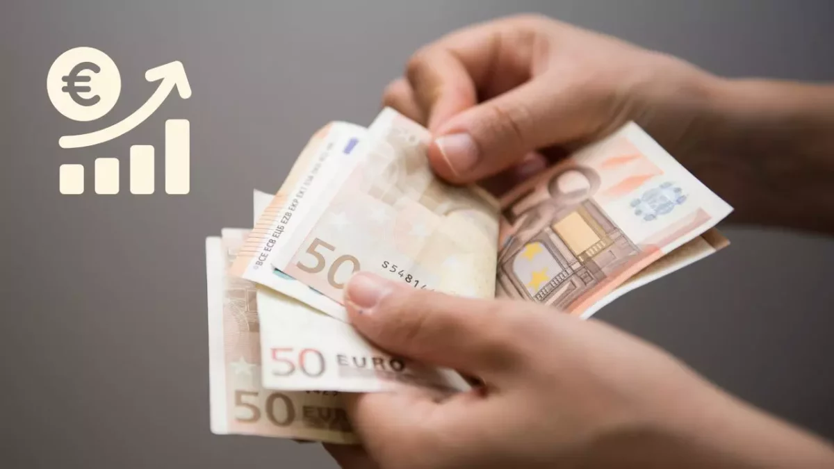 Osoba drží euro bankovky, symbol rastu príjmov.