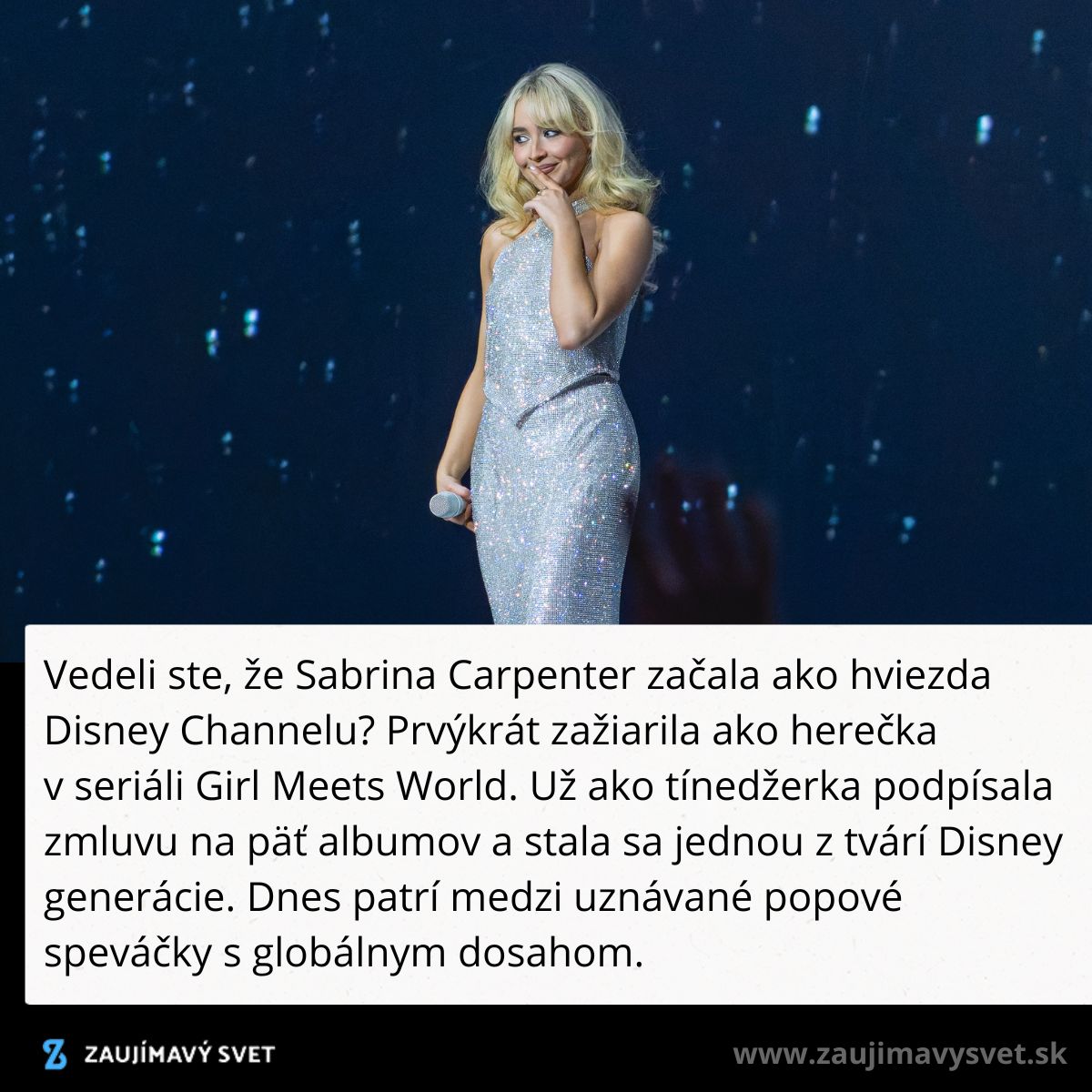 Speváčka v trblietavých šatách vystupuje na javisku s mikrofónom v ruke, usmieva sa na publikum.