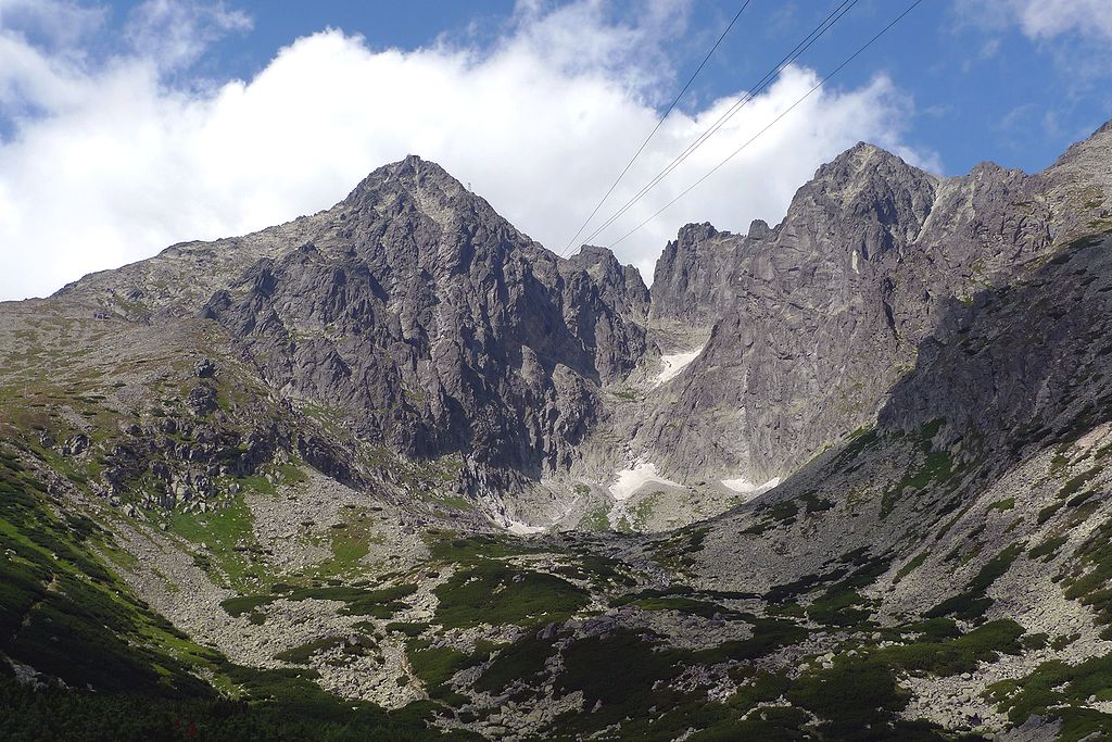 Vysoké Tatry: majestátne skalnaté vrcholy pod modrou oblohou s bielymi oblakmi, príroda Slovenska v celej kráse.