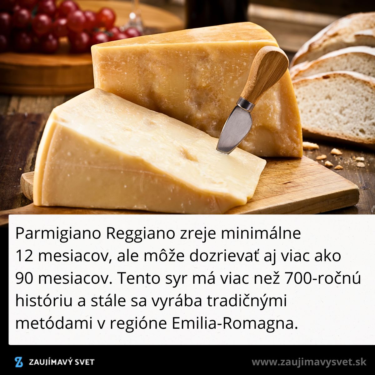 Kúsok syra Parmigiano Reggiano s nožom na drevenej doske, vedľa hrozna a chleba.