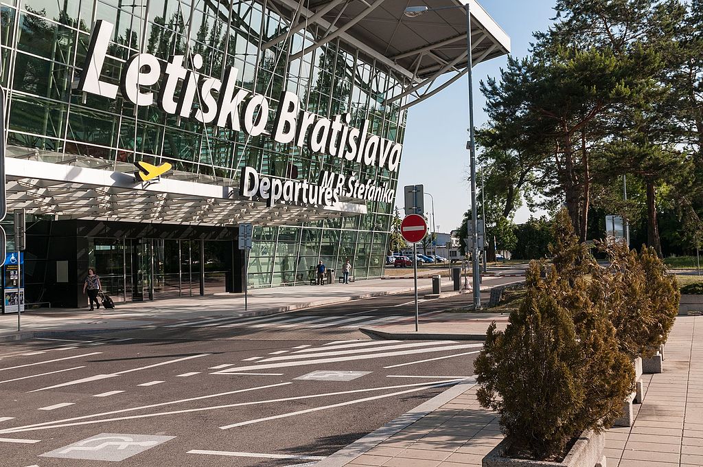Letisko Bratislava, odletová hala, vonkajšia fasáda s presklenými stenami a zeleňou okolo.