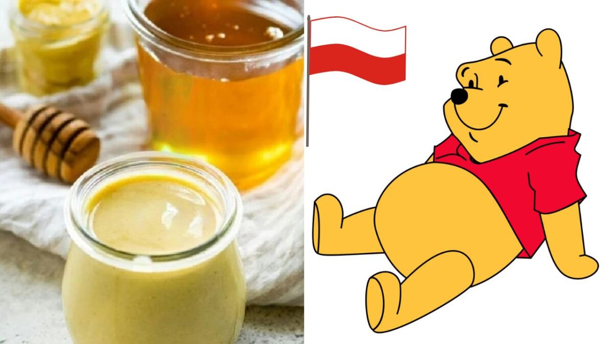 Med v pohári s drevenou paličkou a postavička medveďa v červenom tričku s vlajkou na pozadí.