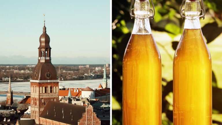 Panoráma mesta s kostolnou vežou a dve sklenené fľaše s hnedým nápojom na slnku.