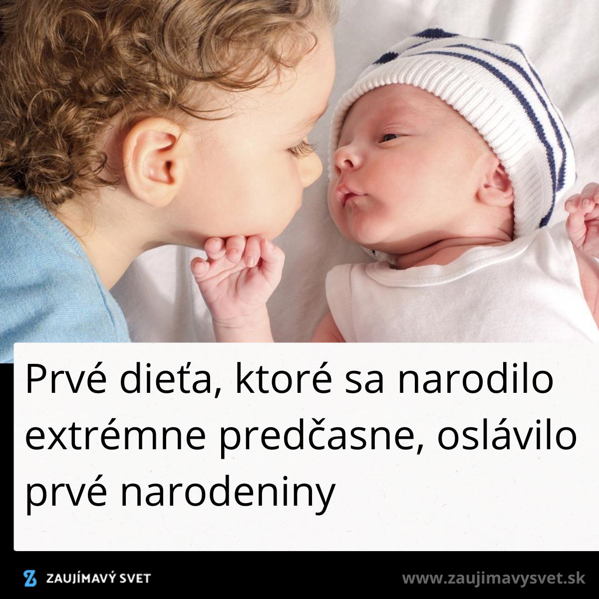 Dieťa v modrom tričku dáva pusu novorodencovi v bielom oblečení, ktorý má na hlave čiapku.